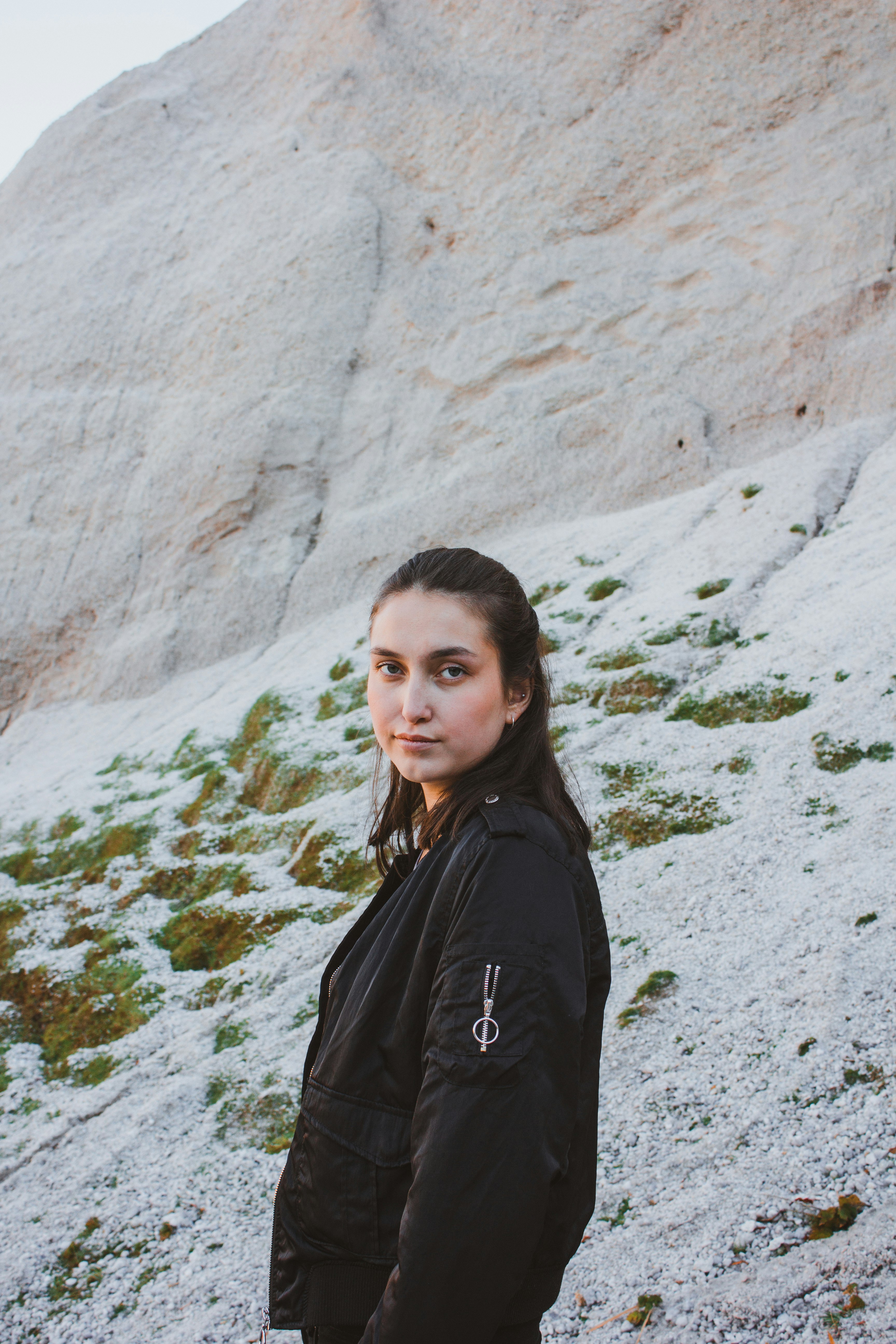 woman standing beside rock formation